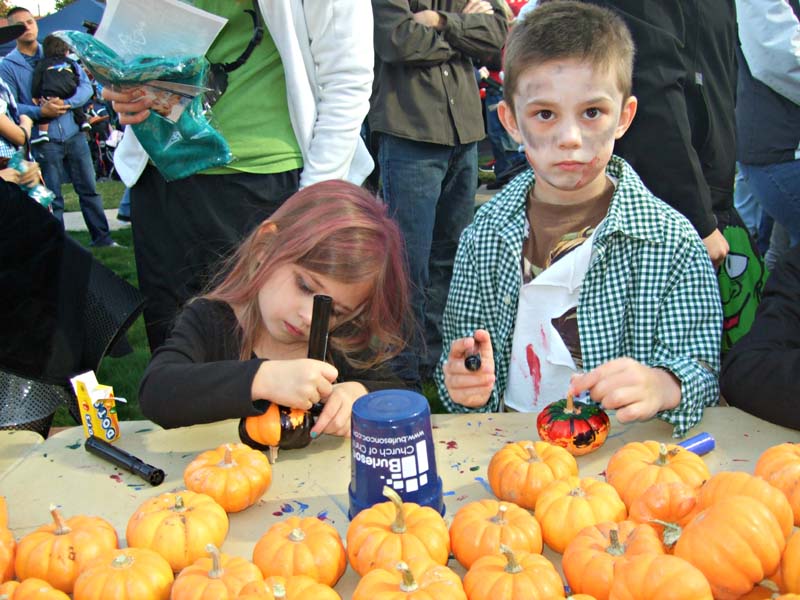 photo of kids decorating pumpkins